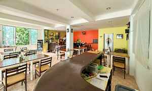 Billede af et indendørsmiljø med borde, stole og farverige vægge. (AI-genereret tekst)