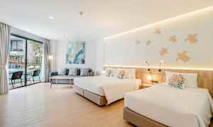 Værelse med to senge, en sofa og et bord tæt på et stort vindue med udsigt. (AI-genereret tekst)