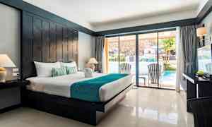 Hotelværelse med stor seng og moderne møbler samt udsigt til poolområdet gennem glasdøre. (AI-genereret tekst)