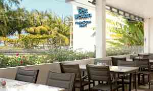 Udendørs serveringsområde med udsigt over frodige træer og blomster. (AI-genereret tekst)