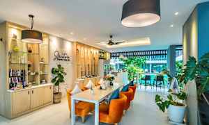 Billede af en moderne café med orange stole og grøn indretning. (AI-genereret tekst)