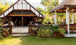 En åben restaurant med en traditionel bygning i grønne omgivelser. (AI-genereret tekst)