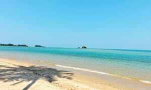 Sandstrand med klart blåt hav og nogle små øer i baggrunden. (AI-genereret tekst)