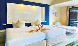 Billede af et hotelværelse med to enkeltsenge, et dekorativt håndklædehjertedesign og en dagseng ved siden af. (AI-genereret tekst)