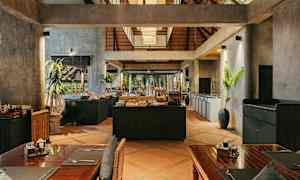 Interiørbillede af en restaurant med rustik indretning, træborde og en buffetstation i midten. (AI-genereret tekst)