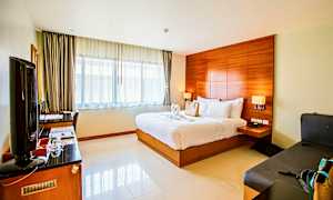 Et hotelværelse med en dobbeltseng, skrivebord, tv og siddepladser. (AI-genereret tekst)