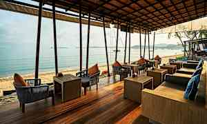 Udendørs servering med siddepladser ved havet. (AI-genereret tekst)