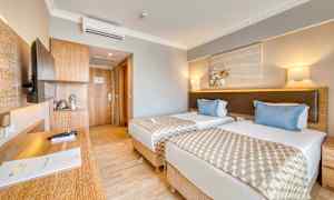 Hotelværelse med to enkeltsenge, et skrivebord og en dør til badeværelset. (AI-genereret tekst)