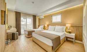 Et hotelværelse med to senge, moderne indretning og en altan. (AI-genereret tekst)