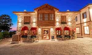 En stenbygning med røde baldakiner og siddepladser på et stenbelagt torv. (AI-genereret tekst)