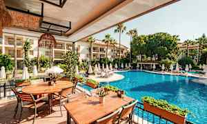 Billede af en udendørs swimmingpool med liggestole omkring og borde på en terrasse. (AI-genereret tekst)