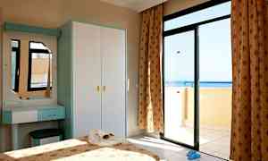 Et soveværelse med en åben altandør, der viser havudsigten. (AI-genereret tekst)