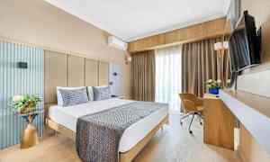 Billede af et hotelværelse med en dobbeltseng, skrivebord, stol og TV. (AI-genereret tekst)