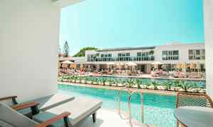 Privat poolområde med udsigt til et moderne hotelkompleks. (AI-genereret tekst)