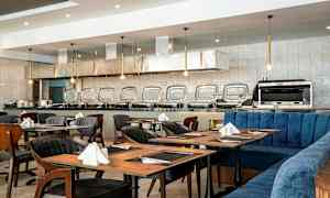 Restaurant med dækkede borde og en buffetdisk i baggrunden. (AI-genereret tekst)