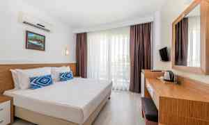 Et hotelværelse med dobbeltseng, skrivebord og altan. (AI-genereret tekst)