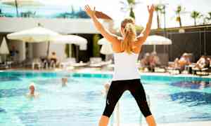 Person står foran en pool og har hænderne oppe. (AI-genereret tekst)