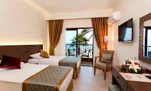 Hotelværelse med to enkeltsenge, vindue med udsigt til palmer og hav. (AI-genereret tekst)