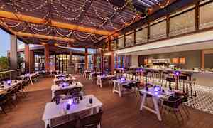 En restaurantterrasse med dækkede borde og lyskæder i loftet. (AI-genereret tekst)