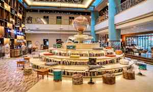 Indretning af et hotel med boghylde omkring en rund siddeplads og dekorativ atmosfære. (AI-genereret tekst)