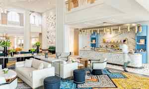 En elegant hotellobby med moderne møbler og en marmordisk. (AI-genereret tekst)