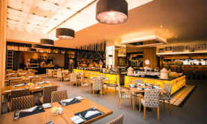 En restaurant med moderne interiør, siddeområder og et åbent køkken. (AI-genereret tekst)