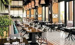 Interiør af en moderne restaurant med borde og stole samt dekorationer. (AI-genereret tekst)