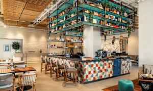 En moderne café- og barindretning med farverigt møblement og udsmykning. (AI-genereret tekst)