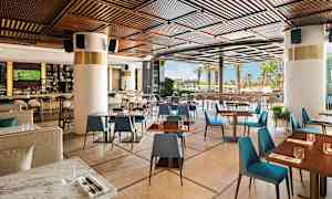 En moderne restaurant med trædetaljer og udsigt til udendørsområdet. (AI-genereret tekst)