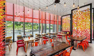 En café med farverige møbler og vægge med dekorative detaljer. (AI-genereret tekst)