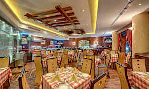 Et spisestueområde med ternede duge og træmøbler, placeret i en elegant restaurant med harmonisk belysning. (AI-genereret tekst)