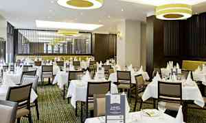 En elegant restaurant med hvide duge og borddækning. (AI-genereret tekst)