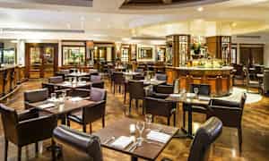 En elegant restaurant med borde og stole, klar til måltider. (AI-genereret tekst)