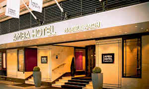 Indgangen til Amba Hotel Marble Arch med skilte og flag. (AI-genereret tekst)