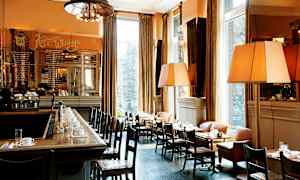 En elegant bistro med bar og borde med duge, arrangeret ved store vinduer. (AI-genereret tekst)