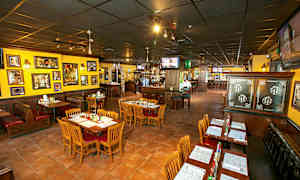 En restaurant med borde og stole, farverige vægge og dekoration. (AI-genereret tekst)