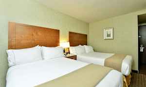 Hotelværelse med to senge, træpaneler som sengegavl og lamper på natbord. (AI-genereret tekst)