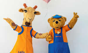 En giraf og en bjørnefigur med tøj laver glade bevægelser mod en hvid baggrund. (AI-genereret tekst)