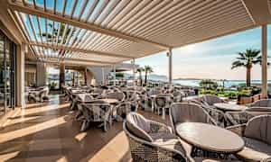 En terrasse med siddepladser, udsigt over kysten. (AI-genereret tekst)