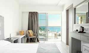 Lyst hotelværelse med moderne indretning og havudsigt. (AI-genereret tekst)