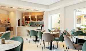 En moderne lounge med borde og stole samt en veludstyret bar. (AI-genereret tekst)