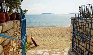 En strand med sand og en blå metalport. (AI-genereret tekst)