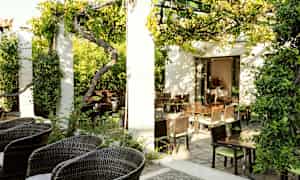 En frodig udendørs serveringsområde med havemøbler og solskinsvejr. (AI-genereret tekst)