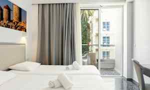 Hotelværelse med to enkeltsenge og balkon med udsigt. (AI-genereret tekst)