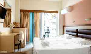 Hotelværelse med dobbeltseng og skrivebord samt balkon med udsigt. (AI-genereret tekst)