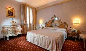 Et elegant indrettet soveværelse med en stor seng, matchende natborde og dekorative møbler. (AI-genereret tekst)