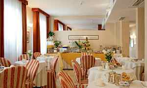 Et spiseområde med dækkede borde og en buffet med frugt og juice. (AI-genereret tekst)