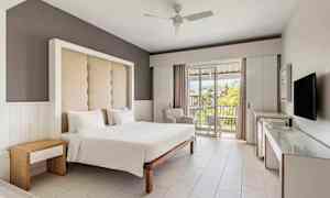 Hotelværelse med en dobbeltseng, moderne interiør og en balkon med udsigt. (AI-genereret tekst)