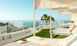 Liggestole på en terrasse med udsigt over havet og byen. (AI-genereret tekst)