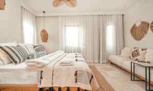 Et lyst og stilfuldt soveværelse med en dobbeltseng, dekorative puder og tekstiler. (AI-genereret tekst)